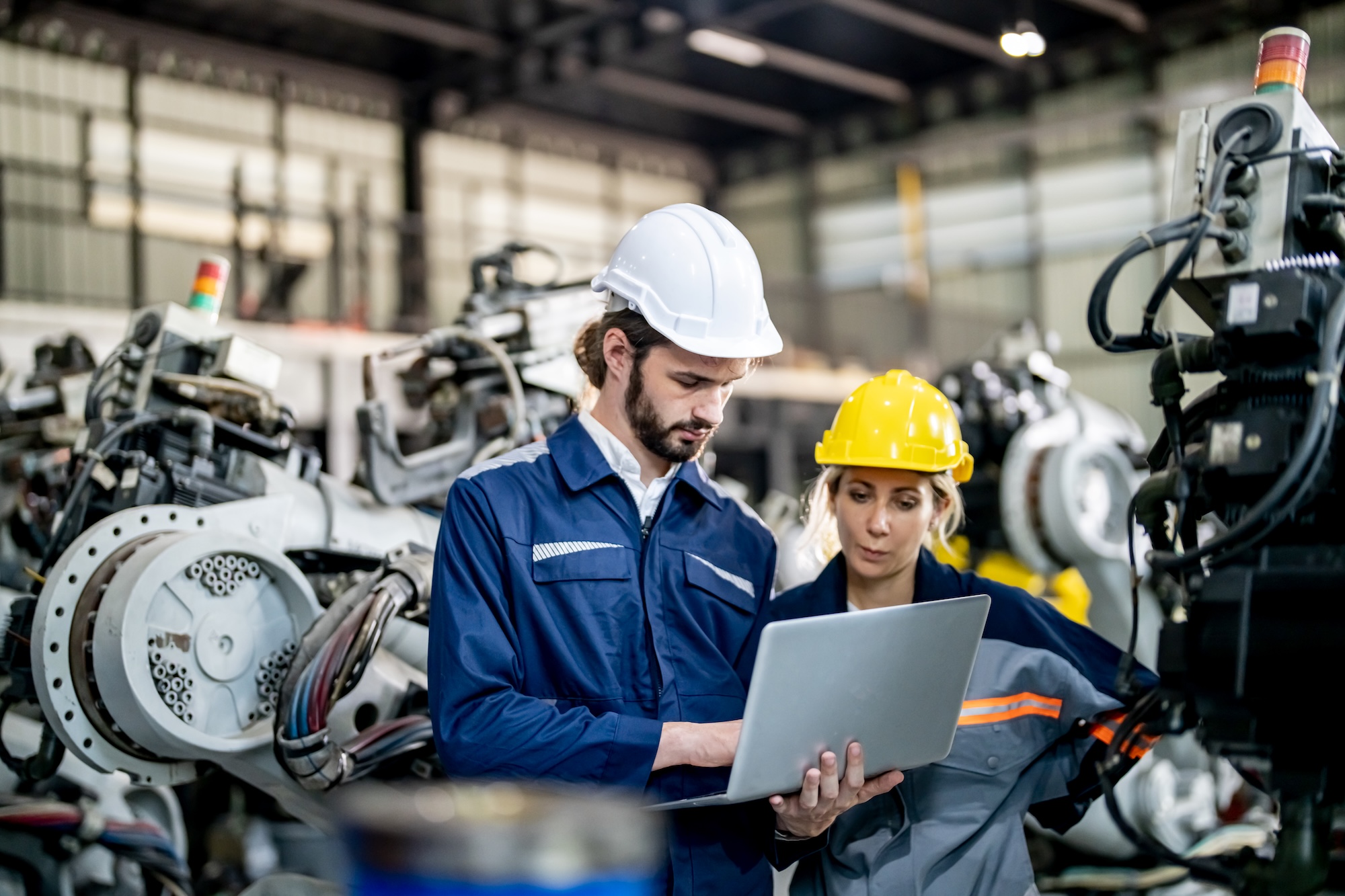 Engineer with robot in automotive parts factory